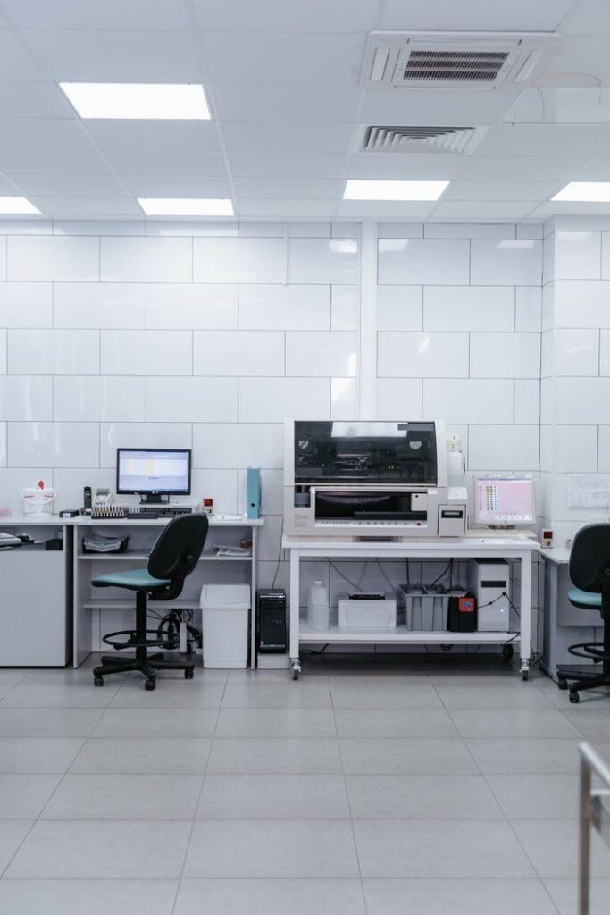 Spacious modern laboratory with computers and office chairs under bright lighting.